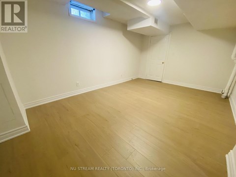 A room with wooden flooring and white walls.