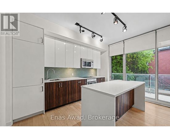A modern kitchen with white cabinets and a wooden island.