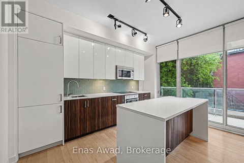 A modern kitchen with white cabinets and a wooden island.