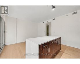 A white kitchen island with wooden drawers in a white room.