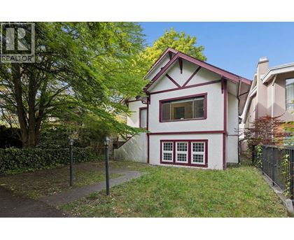 A house with a red roof and white walls with a red window trim.