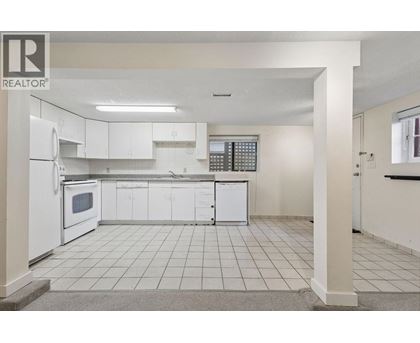 A white kitchen with a refrigerator, microwave, and cabinets.