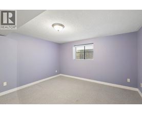 A room with purple walls and a window with blinds.