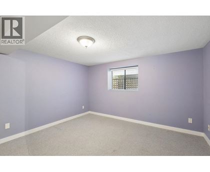 A room with purple walls and a window with blinds.