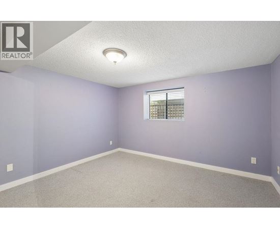 A room with purple walls and a window with blinds.