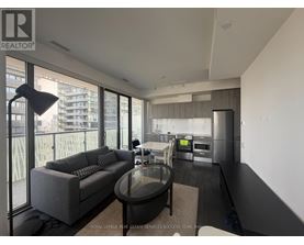 A modern living room with a grey sofa and a glass table.