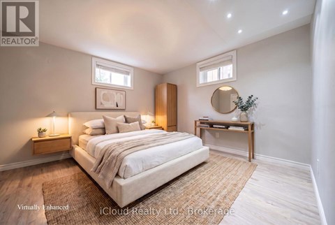 A bedroom with a large bed, a nightstand with a lamp, and a small table with a plant on it.