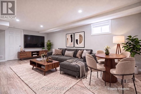 A living room with a grey couch, a wooden coffee table, and a flat screen TV.