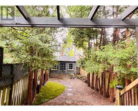 A house is surrounded by a fence and trees.