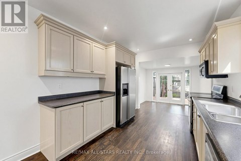 A kitchen with wooden cabinets and a black countertop.