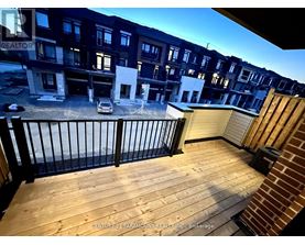 A balcony with a railing and a car parked in the background.