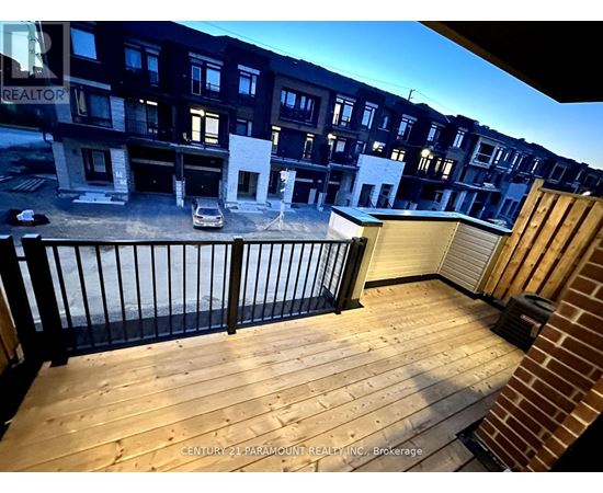 A balcony with a railing and a car parked in the background.