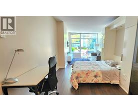 A bedroom with a bed, desk, and chair.