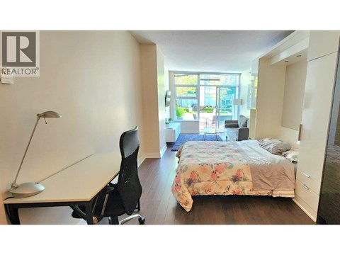 A bedroom with a bed, desk, and chair.