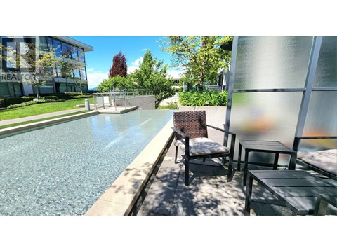 A pool with a chair and table beside it.