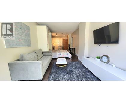 A living room with a grey couch and a coffee table in front of a TV.