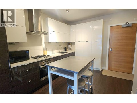 A kitchen with a table and chairs in the middle.