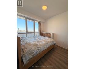 A bedroom with a large bed and a view of the city.
