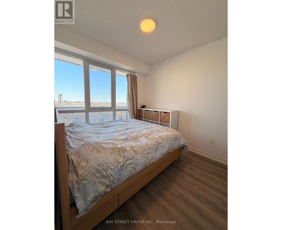 A bedroom with a large bed and a view of the city.