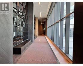A hallway with a marble wall and a bench.
