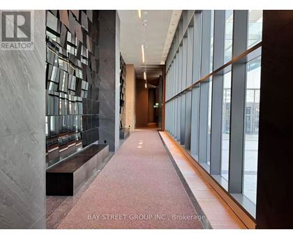 A hallway with a marble wall and a bench.