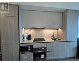 A kitchen with a sink, stove, and cabinets.