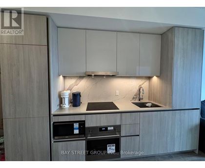 A kitchen with a sink, stove, and cabinets.