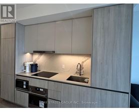 A kitchen with a sink and a stove top oven.