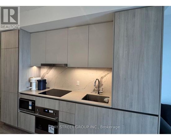 A kitchen with a sink and a stove top oven.