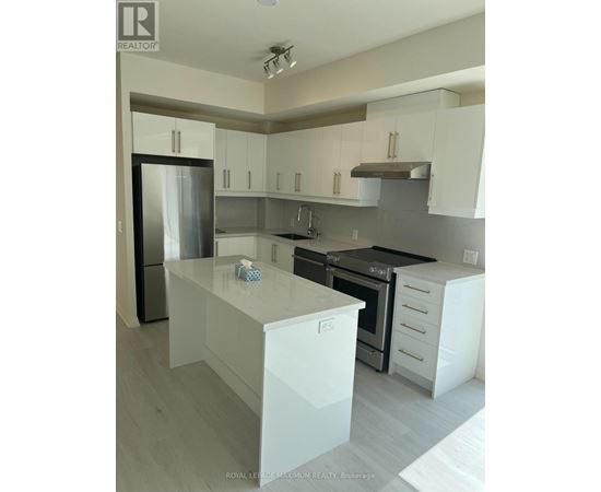 A modern kitchen with white cabinets and a stainless steel refrigerator.