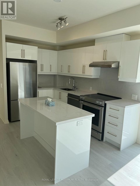 A modern kitchen with white cabinets and a stainless steel refrigerator.