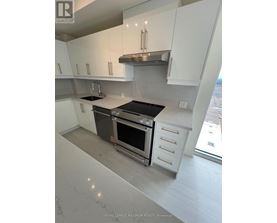 A modern kitchen with white cabinets and stainless steel appliances.