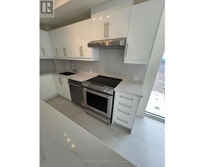 A modern kitchen with white cabinets and stainless steel appliances.