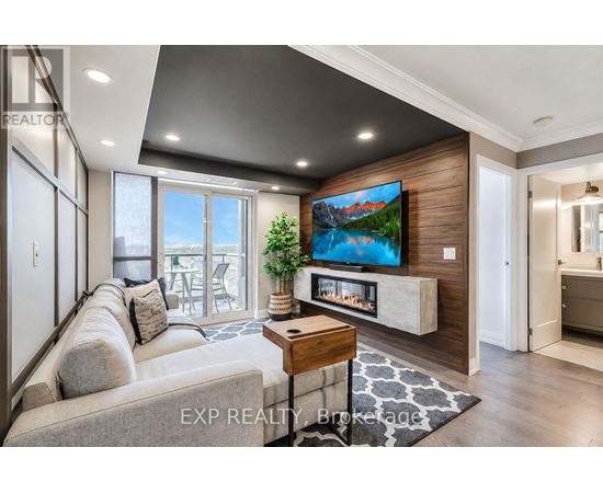 A modern living room with a large grey sofa and a flat screen TV mounted on a wooden wall.