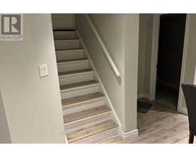 A staircase with a light switch on the wall.