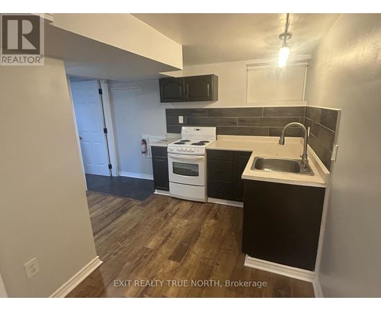 A kitchen with a white stove top oven and a black counter top.