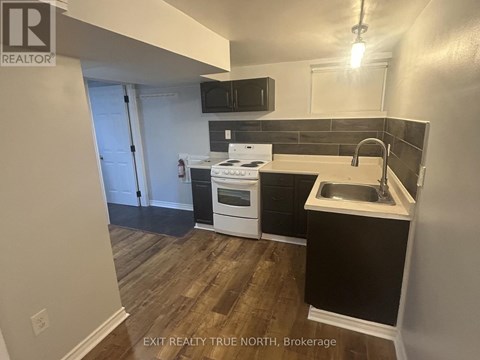 A kitchen with a white stove top oven and a black counter top.
