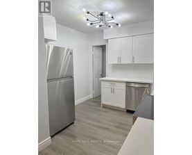 A kitchen with a stainless steel refrigerator and cabinets.