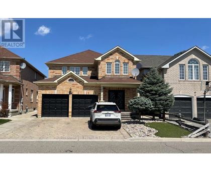 A large house with a car parked in front.