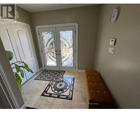 A foyer with a bench, a door, and a clock on the wall.