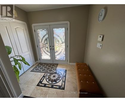 A foyer with a bench, a door, and a clock on the wall.