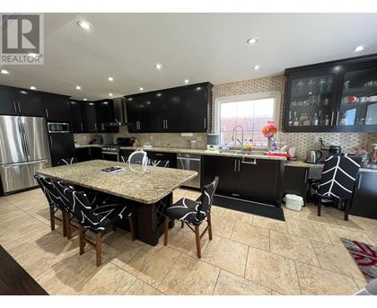 A kitchen with a table and chairs in the middle of it.