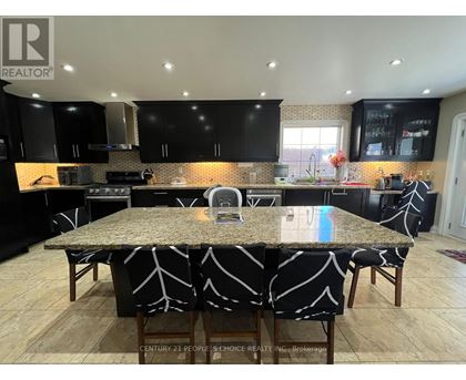 A kitchen with a granite countertop and black cabinets.