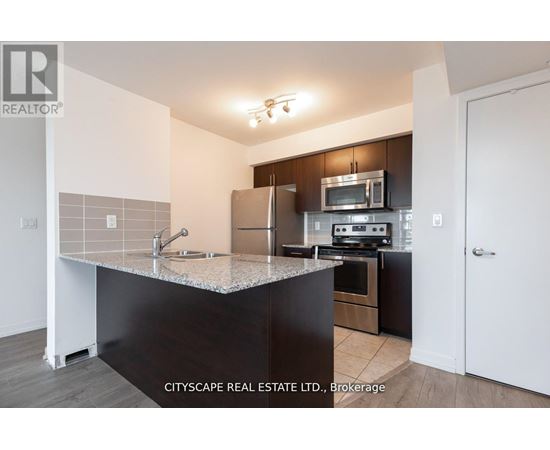 A kitchen with a granite countertop and stainless steel appliances.