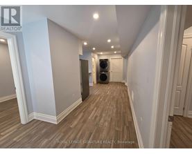 A hallway with wood flooring and white walls.