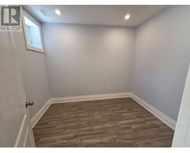 A room with wooden flooring and white walls.