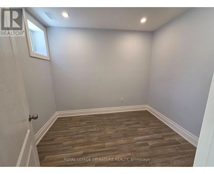 A room with wooden flooring and white walls.