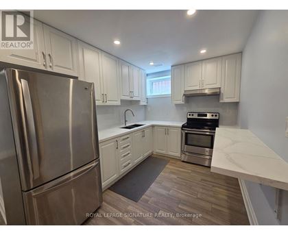 A kitchen with a stainless steel refrigerator and a stove top oven.