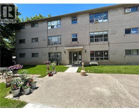 A building with a grey facade and a small garden in front.