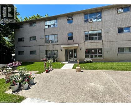 A building with a grey facade and a small garden in front.